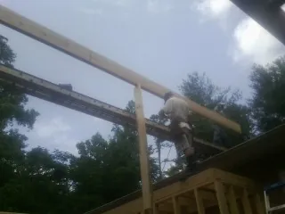 Carpenter setting a ridge beam over a new addition frame — Ice Dam Removal by Roofing Brothers in Convent Station