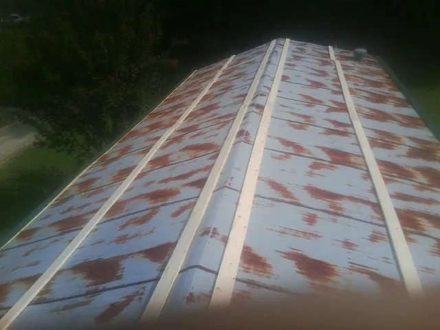 Rusted metal roof panels with new wood purlins before replacement — Storm Damage Roof Repair in Convent Station by Roofing Brothers