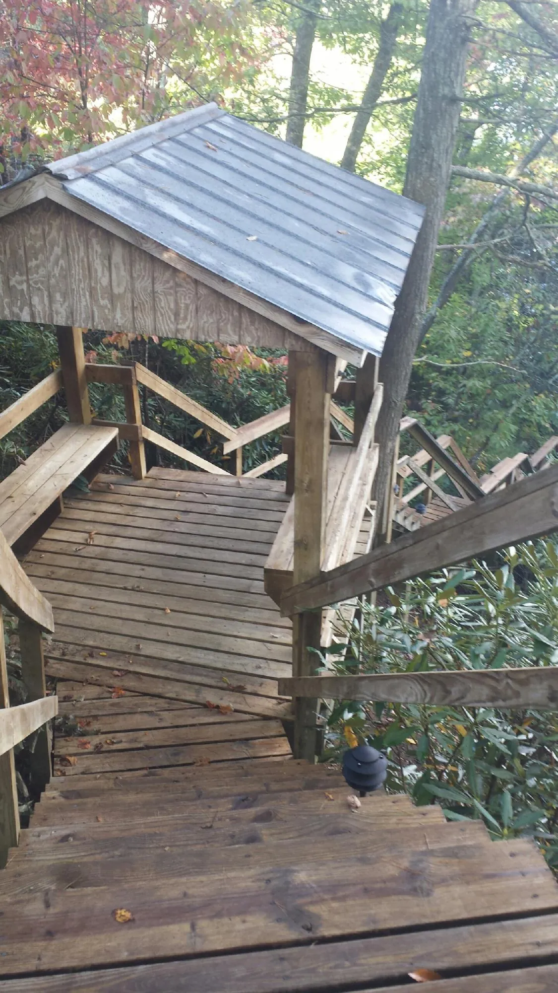 Metal roofed shelter over wooden steps on a wooded walkway — Skylight Repair & Installation work by our crew in Convent Station