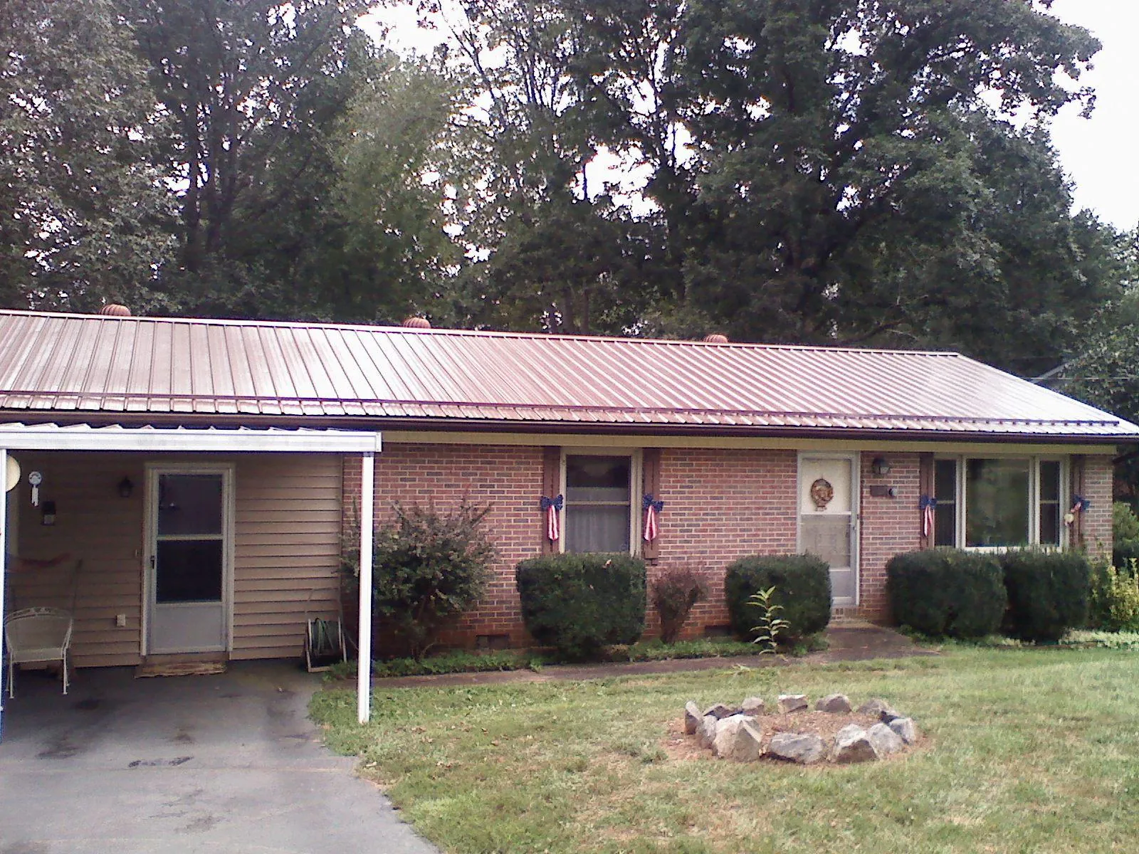 Bronze metal roof and carport on a brick ranch home — Roof Repair work by our crew in Convent Station